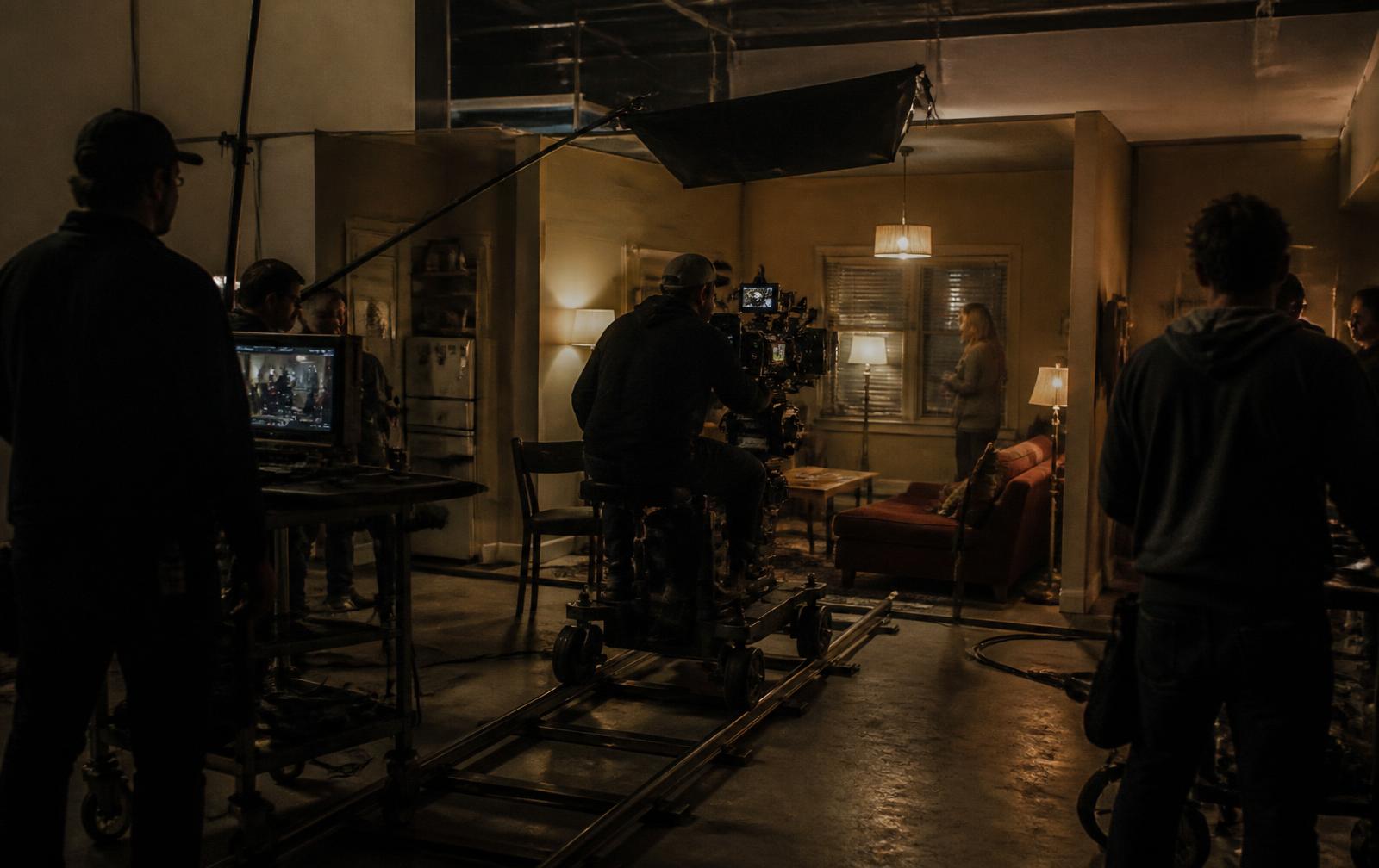 Camera crew on a dolly shooting inside a constructed apartment set