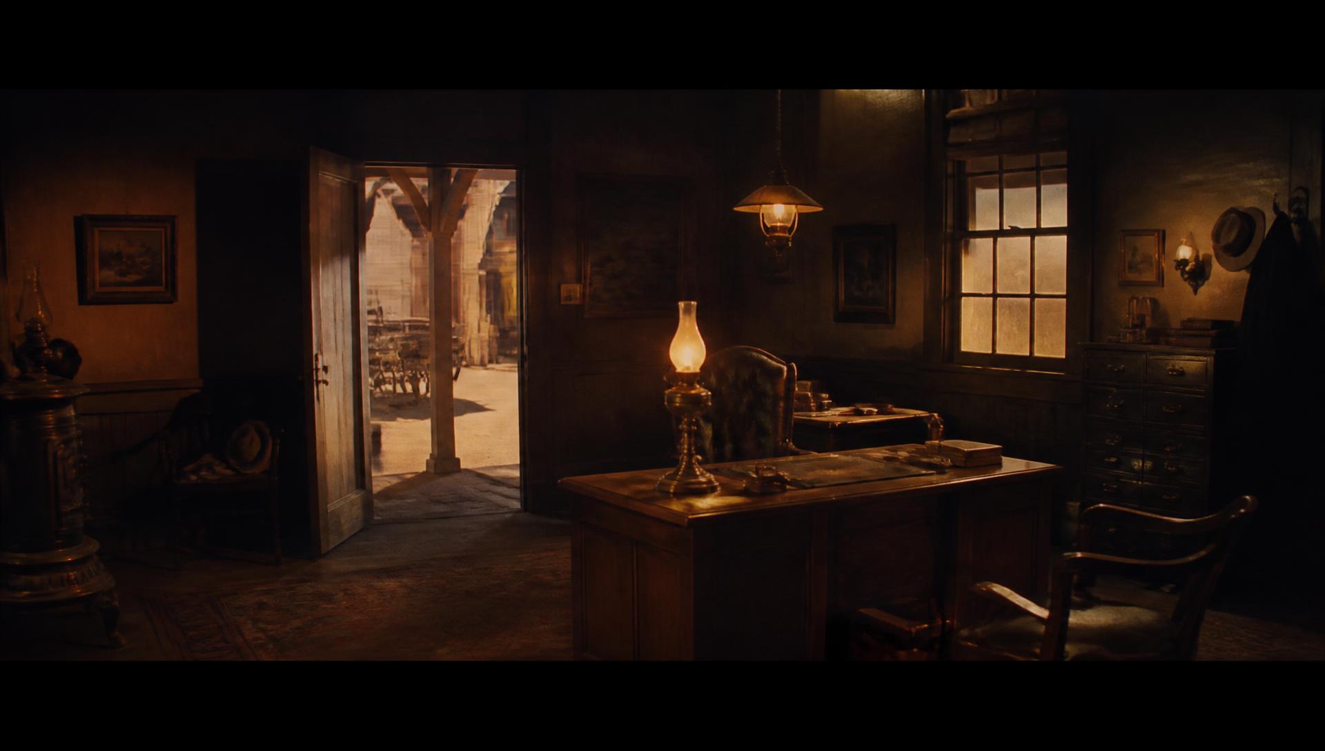 Constructed Western ranch office film set lit with warm practical lamps